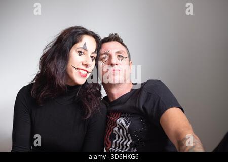Ehemann und Ehefrau mit Gesicht für Karneval-Porträts auf hellem Hintergrund. Der Mann und die Frau sind achtunddreißig Jahre alt und kaukasischer Herkunft Stockfoto