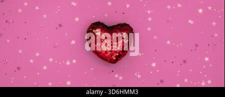 Weihnachts- oder Valentinskomposition aus glühender roter Herzdeko und Glitzer auf rosa Oberfläche. Frohe weihnachten und glückliches Neues Jahr 2021, glücklich Stockfoto