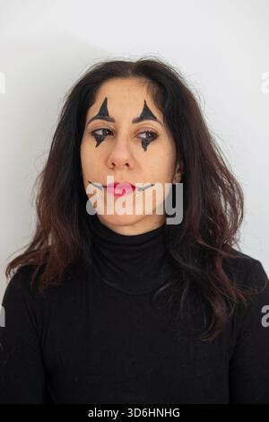 Schöne vierzig-jährige Frau mit Halloween Make-up posiert mit einem intensiven Ausdruck auf weißem Hintergrund Stockfoto
