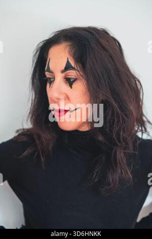 Frau mit Gesicht zur Seite geschminkt. Die Frau ist 38 Jahre alt und hat lange schwarze Haare Stockfoto