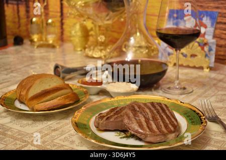 Nahaufnahme von gegrilltem Steak mit Rotwein in Karaffe Stockfoto