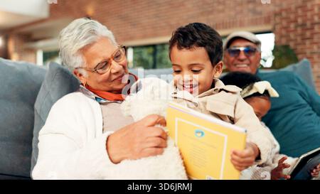 Großmutter, Junge und Lesebuch auf Sofa mit Lernen, glücklich oder verbunden im Wohnzimmer. Senioren, Kinder und entspannen Sie sich auf der Couch mit Literatur Stockfoto