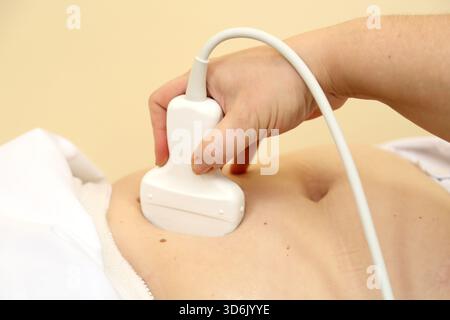 Modernes Ultraschallgerät. Sonographische Untersuchungen innerer Organe. Eine Frau, die sich einer Ultraschalluntersuchung ihrer Bauchhöhle unterzieht. Ultraschalluntersuchung Stockfoto