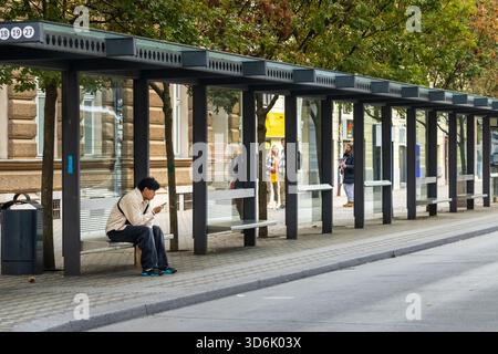 Ljubljana, Slowenien 19. Oktober 2025 Moderne Bushaltestelle mit Glasplatten und Bänken Stockfoto