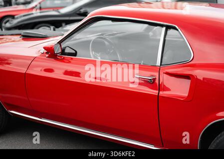 Nahaufnahme der Seite eines klassischen Ford Mustang aus dem Jahr 1969: Kotflügel, Seitentür, Fenster und hinteres Seitenblech. Der Fokus liegt auf der Karosserie des Fahrzeugs Stockfoto
