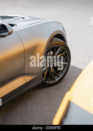 Satin-graues Auto auf einem Parkplatz. Seitenansicht des vorderen Teils eines modernen Sportwagens. Stockfoto