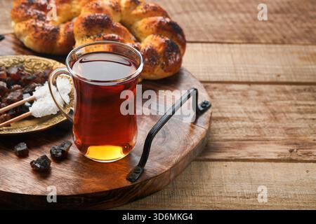 Türkischer schwarzer Tee. Eine Glasschale türkischer schwarzer Tee und knuspriger türkischer traditioneller Bagel auf altem Rustick-Hintergrund. Frühstücksgebäck-Konzept. Traditionelles türkisches Heißgetränk. Stockfoto