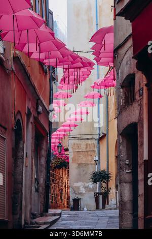 Grasse, Frankreich - 23. Juli 2023: Berühmte pinkfarbene Regenschirme schmücken die zentralen Straßen von Grasse Stockfoto