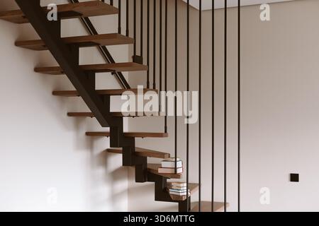 Moderne schwimmende Treppe mit Holztreppen und schwarzem Metallgeländer. Auf den Stufen dieses modernen Treppenhauses liegen Bücher, die einen Tou hinzufügen Stockfoto