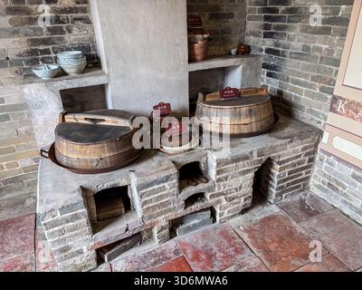Nachbildung einer alten chinesischen Küche mit einem Holzofen und traditionellen hölzernen Kochtöpfen, gefunden im Dorf Zili, Kaiping, China. Stockfoto