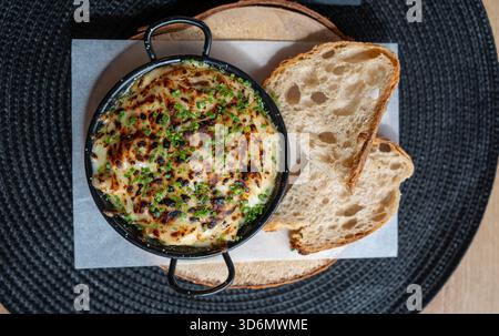 Dip mit gebackenem Käse und geröstetem Brot Stockfoto