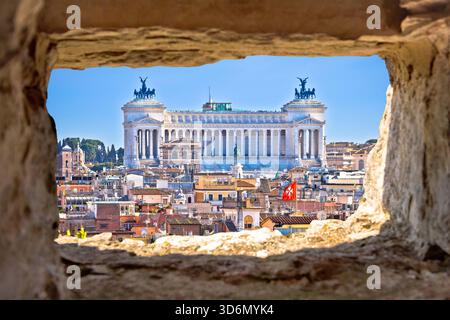 Rom. Die ewige Stadt Rom ist ein Wahrzeichen der Dächer mit Blick auf die Skyline durch ein Steinfenster, die Hauptstadt Italiens Stockfoto