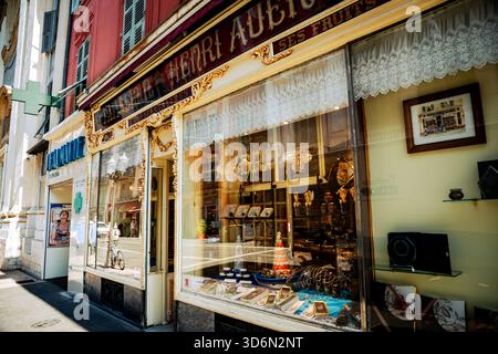 Kunstvolle Ladenfront mit goldenen Schildern und Schaufenstern entlang einer Fußgängerzone in einer provenzalischen Stadt. Stockfoto
