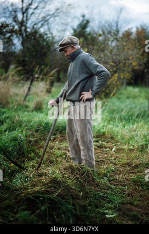 Ein älterer Mann, der auf einem Feld steht Stockfoto