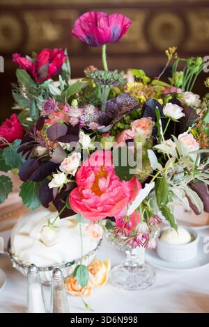 Herzstück mit auffälligem Blumenmuster und rosa Mohnblumen und Gartenrosen Stockfoto