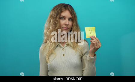 Frau Hand hält Studio blonde junge Haftnotiz Frage Türkis weckt Neugier. Stockfoto