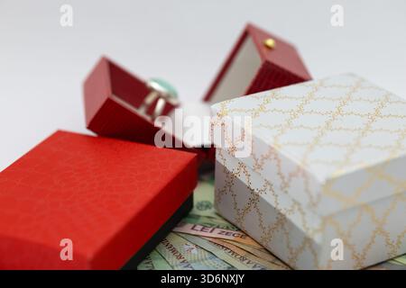 Einzigartiger Angebots-/Verlobungsring und wunderschöne Geschenkboxen auf rumänischen Leu-Banknoten (lei). Das Konzept von Luxus, Ausgaben, Vermögen und Geschenken. Stockfoto