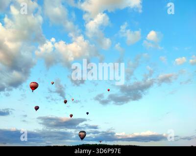 Heißluftballonfestival, Luftfahrt, viele Heißluftballons am Himmel bunte Luftschiffballons fliegen über den blauen Himmel mit weißen Wolken Stockfoto