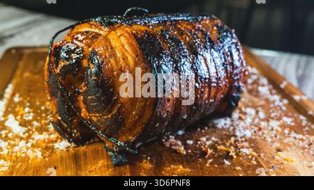 Ganze Schweineschaschu-Rolle auf einem Holzbrett, perfekt getoastet und goldbraun außen. Bereit zum Schneiden für Ramen-Schüsseln. Mariniert, zart und aromatisch. Stockfoto