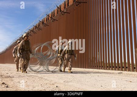 US-Marines mit Combat Logistics Battalion 15 (CLB 15), Combat Logistics Regiment 17, 1st Marine Logistics Group, der Joint Task Force-Southern Border (JTF-SB) zugewiesen, tragen den Draht in Position zur Installation in Yuma, Ariz., 17. November 2025. Die Maßnahmen des CLB 15 zur Verstärkung von Barrieren zielen darauf ab, die physischen Sicherheitsmaßnahmen an der bestehenden südlichen Grenzbarriere zu verbessern. JTF-SB führt umfassende, agile und bereichsübergreifende Operationen zur Unterstützung des US-Zoll- und Grenzschutzes durch, um die territoriale Integrität der Vereinigten Staaten zu schützen und 100% die operative Kontrolle des Südens zu erreichen Stockfoto