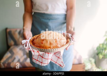 Frau hält frisch gebackenen Apfelkuchen in der Küche für Thanksgiving-Feier Stockfoto