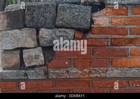 Rote Ziegelwand Mit Grauem Patch – Rustikales Mauerwerk In Nahaufnahme Stockfoto