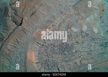 Von oben nach unten auf eine riesige Müllhalde oder Schlackenhaufen. Abstrakte geomorphe Textur mit Blau-Grau- und Orangetönen, die starke Landdegradation zeigen. Stockfoto