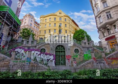 Eine historische Steintreppe und ein Torbogen, bedeckt mit farbenfrohen Graffiti in Wien Stockfoto