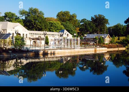 Ein Café im Piedmont Park in Atlanta spiegelt sich an einem sonnigen Tag im ruhigen Wasser des Sees wider Stockfoto