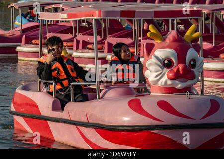 Changzhou, China. November 2025. Die Menschen fahren mit einem Drachen-förmigen Tretboot auf dem See im ökologischen Park. Quelle: SOPA Images Limited/Alamy Live News Stockfoto