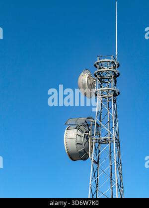 Unmarkierter Mobilfunkmast und Antennen isoliert vor blauem Himmel. Stockfoto