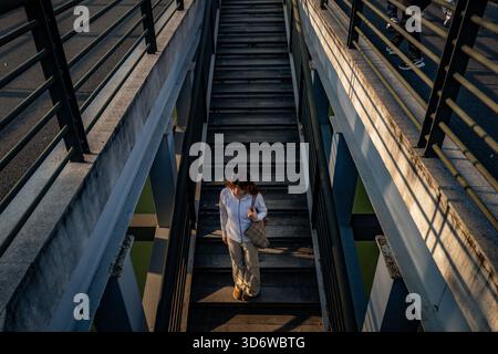 Changzhou, China. November 2025. Eine Frau läuft eine Treppe unter einer Brücke hinunter. (Foto: Sheldon Cooper/SOPA Images/SIPA USA) Credit: SIPA USA/Alamy Live News Stockfoto