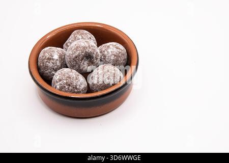 Schokoladentrüffel in einer kleinen Steingutschale auf einem schlichten Hintergrund, geeignet für Desserts und Süßwaren. Stockfoto