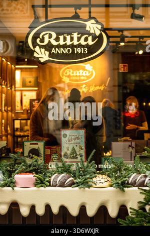 Ein festliches Weihnachtsfenster in einem Schokoladengeschäft in der Altstadt von Vilnius mit warmen Lichtern, Weihnachtsdekorationen und handwerklicher Schokolade Stockfoto