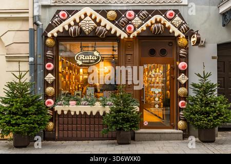 Ein festliches Weihnachtsfenster in einem Schokoladengeschäft in der Altstadt von Vilnius mit warmen Lichtern, Weihnachtsdekorationen und handwerklicher Schokolade Stockfoto