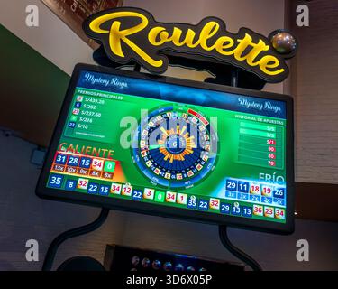 Helles elektronisches Roulette-Display in einer modernen Casino-Umgebung mit Gewinnzahlen, heißen und kalten Ergebnissen und farbenfroher Wetten-Oberfläche. Stockfoto