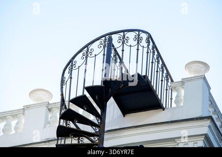 Nahaufnahme einer wunderschönen geschmiedeten Wendeltreppe auf der Seite eines Hauses Stockfoto