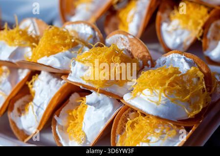 Köstliche thailändische Straße Dessert, Kanom Buang, Thai knusprige Pfannkuchen oder Thai Krepp, mit verschiedenen Füllungen wie süß weiß Pudding Sahne und golden Stockfoto
