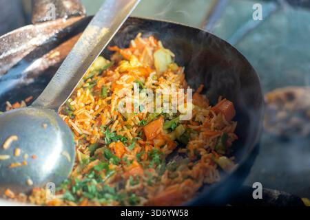 Gesundes veganes Essen - Gemüsepilaw oder Biryani aus der indischen Küche, Nahaufnahme. Kochen von Biryani in einem Straßencafé auf einem lokalen Markt in Indien. Stockfoto