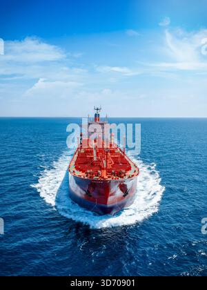 Luftaufnahme eines roten Rohöltankers, der mit Geschwindigkeit über den Ozean mit Kopierraum am Himmel fährt Stockfoto