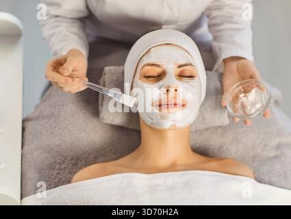 Professionelle Kosmetikerin, die Schönheit Gesichtsreinigung Anti-Aging-Maske für Kunden im Schönheitssalon anwendet Stockfoto