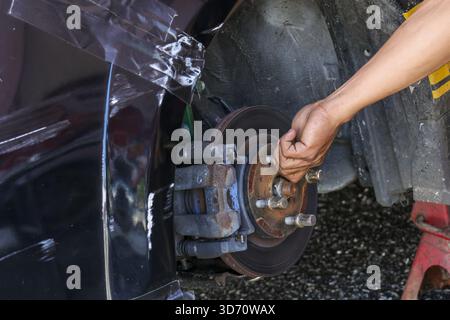 Fokussierter Mechaniker, der Autoreparatur und -Wartung durchführt. Fahrzeugwartung am Scheibenbremssystem, Nahaufnahme von Bremsrotor und cali Stockfoto