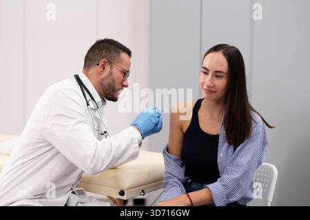 Weiblicher Arzt injiziert Diabetes-Impfstoff in den Arm des Mannes, medizinische Behandlung. Stockfoto
