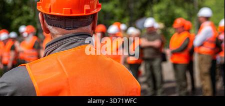 Arbeitergruppe mit Weste, Sicherheit. Baumeister. Professionelles Team und Porträt eines Ingenieurs, der in einer Gruppe, einer industriellen Fabrik, steht. Arbeiten Stockfoto
