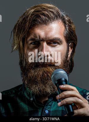 Mann, der ein Mikrofon hält und singt. Mann singt mit einem Mikrofon Stockfoto