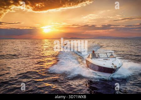 Luftaufnahme eines Motorschnellbootes, das während des goldenen Sonnenuntergangs im Sommer über das Meer fährt Stockfoto