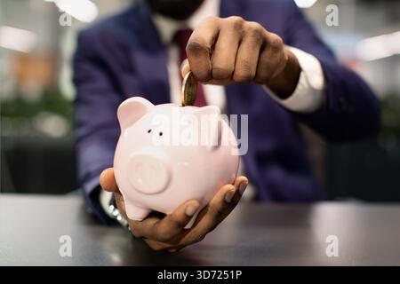 Nicht erkennbarer afroamerikanischer Mann im Anzug, der Einsparungen macht Stockfoto