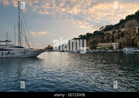 Blick auf den Hafen von Porto Luca Ferrari, mit der Cappelletta, kleine Kapelle am kap Punta Santa Croce, bei Sonnenuntergang, Alassio, Ligurien, Italien Stockfoto