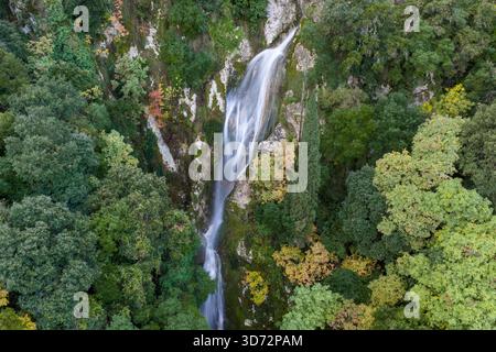 Majestätischer versteckter Wald Wasserfall, der durch üppiges Grün und Herbstlaub von Aerial View – ruhige Naturlandschaft, unberührte Wildnis, S Stockfoto