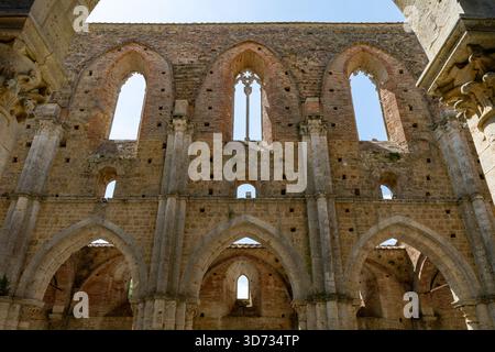 Gotische Innenbögen und spitze Fenster der dachlosen Zisterzienserabbazia di San Galgano in der Nähe von Chiusdino in der Toskana. Stockfoto